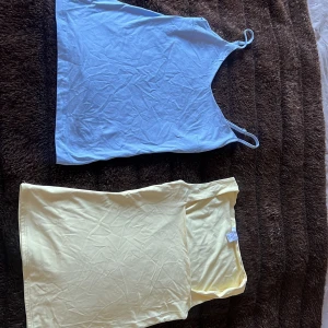 Blå linne från 157 & gul tubtopp Amisu XS - Säljer ett ljusblått linne med smala axelband från 157 och en ljusgul axelbandslös tubtopp från Amisu. Båda är i stretchig bomullsblandning och har enkel, clean design. Perfekta för sommardagar eller att styla lager på lager.