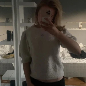 Beige stickad tröja med puffärm - Superfin beige stickad tröja med korta puffärmar. Har använts fåtal gånger och är lite nopprig men annars i väldigt bra skick!
