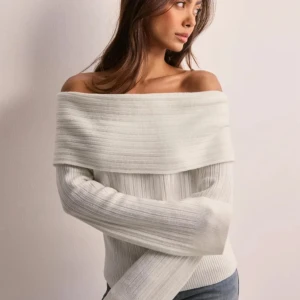 Vit ribbad offshoulder stickad tröja - Säljer denna fina offshoulder stickade tröjan från Nelly i storlek xs! Finns inte längre att köpa på hemsidan. Den är använd 1 gång och därav som ny🤍 original pris 400kr