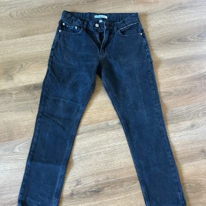 Svarta skinny jeans Calvin Klein - Svarta jeans från Calvin Klein Jeans med klassisk femficksdesign och smal passform. Byxorna har CK-detalj på bakfickan och metallknapp framtill. Perfekta för dig som gillar en stilren och enkel look.