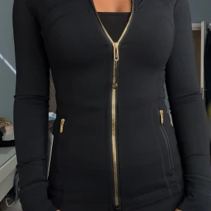Lululemon define jacket black/gold zipper - Säljer en supersnygg ny lululemon define jacket i färgen black/gold. Storlek 4 motsvarar XS-S
