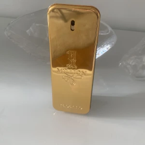 1 Million Eau de Toilette herr - Stilren och ikonisk parfym med guldig design från Paco Rabanne. Perfekt för dig som vill sticka ut och ge ett lyxigt intryck. Flaskan har en modern look som passar unga vuxna. Volym och ingredienser syns ej på bilderna.