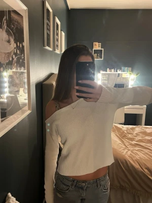 Gullig vit off-shoulder - Trendig vit stickad tröja med off-shoulder design och lång ärm. Tröjan är croppad och har en ribbad struktur som ger en snygg och avslappnad look. Storlek står tyvärr inte men skulle säga Xs💗