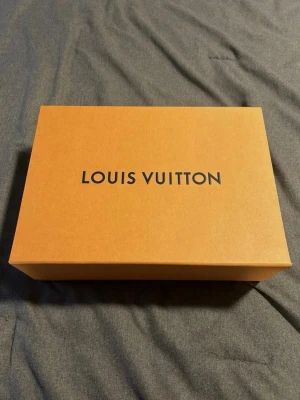 Louis Vuitton  Trainers - Snygga Louis Vuitton sneakers i blått och vitt med denimdetaljer och klassiska LV-loggor. Skorna har snörning, rund tå och platt sula. Perfekta för dig som vill sticka ut med exklusiva och trendiga sneakers i premiumkvalitet.