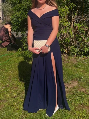 Marinblå balklänningklänning! - Världens vackraste balklänning!💙Marinblå off-shoulder klänning. Figurnära, otroligt skönt material!  Slutsåld i butik. Jag bär vanligtvis S och denna satt perfekt, men är väldigt stretchiga så passar mycket väl en 34 eller 38a! Endast använd en gång så mycket bra skick! Passar även till en annan festlig tillställning! 