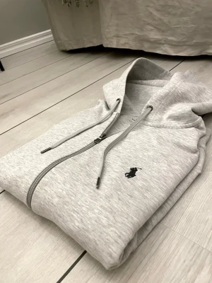 Ralph Laurent full zip  - Säljer denna ralph lauren zip färg grå, inköpt från Design Only, storlek S i bra skick