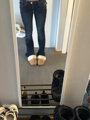 Mörkblå bootcut jeans från True Religion - Snygga mörkblå lågmidjade bootcut jeans från True Religion. Jag har sytt in dem med en symaskin som gjort att dem är ännu lägre och sitter bättre. Sydde in dem för ett långt tag sen och de har inte gått upp, de funkar jättebra och tvätta dem osv utan att stygnen går upp.