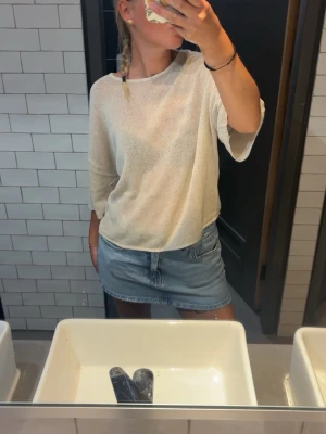 Vit lös stickad topp - Säljer en vit, lös stickad topp med trekvartsärm. Toppen har en avslappnad passform och är perfekt för varmare dagar. Enkel och stilren design som passar till det mesta.