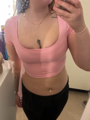 Ljusrosa croppad topp från Shein - Söt ljusrosa croppad topp från Shein med korta ärmar och bred, djup urringning.