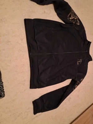 Svart ziptröja från Classilal S - Jag säljer en tröja i storlek S som är i helt nytt skick. Den är aldrig använd och har fortfarande alla etiketter kvar. Perfekt för dig som vill ha en ny tröja till ett bra pris.  Priset är 250 kr, vilket jag tycker är ett riktigt bra pris med tanke på att den är helt ny. Jag är öppen för snabba affärer!  Tveka inte att höra av dig om du är intresserad eller har några frågor. Först till kvarn gäller!