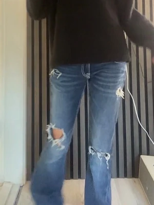 Blå slitna straight jeans - Säljer ett par blå jeans med slitningar och hål på benen. Jeansen har en rak passform och klassisk femficksdesign. Storlek xxs från ginas nya avdelning! Bara å skriva om ni vill ha fler bilder!