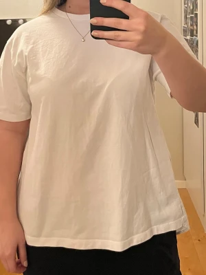 Vit T-shirt med rosetter i ryggen - Superfin vit T-shirt med rosetter i ryggen. Den är från Zara i storlek S men passar även M☺️