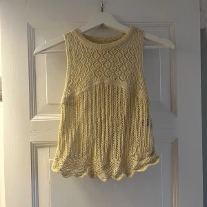 Beige stickad ärmlös topp - Supersöt beige stickad topp med ärmlös design och vackert hålmönster. Toppen har rund halsringning och vågig kant nertill🤎 aldrig använd 