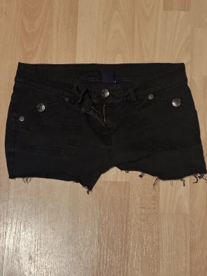 Svarta jeansshorts med rå kant - Svarta jeansshorts med coola fickor , köpt från beyond retro! Tyvärr fungerar inte dragkedjan därav priset 