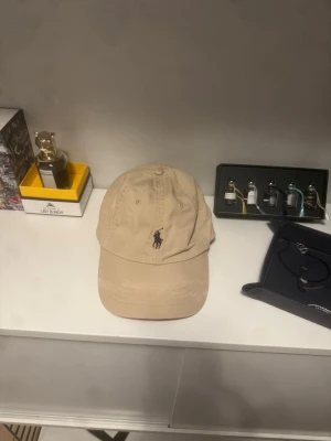 Polo Ralph lauren keps - Säljer en beige färgad keps från polo knappt andvänd.