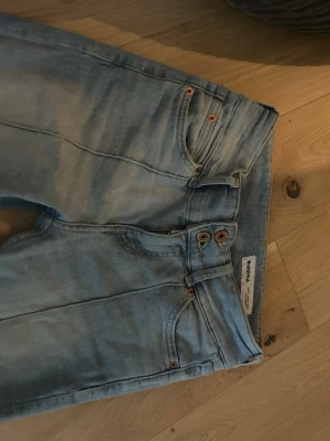 Ljusblå low waist jeans från Bershka - Säljer ett par ljusblå low waist jeans från Bershka med dubbla knappar i midjan och klassisk femficksdesign