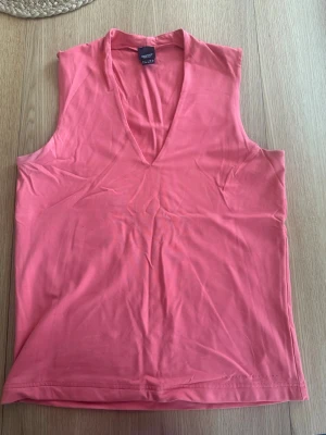 Rosa ärmlöst linne med v-ringning - Snygg rosa linnetopp från Esprit med djup v-ringning och ärmlös design. Tillverkad i mjukt och stretchigt material som känns skönt mot huden. Perfekt för varma dagar och enkel att matcha med olika stilar. Den är storlek xl men jag tycker snarare att den är i storlek m.