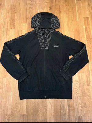 Svart vindjacka från McKenzie L - Säljer en snygg jacka från McKenzie i storlek L. De är en vind/regnjacka och är en perfekt jacka för regn och vind väder. Jackan är i mycket fint skick och är i gott som nyskick och aldrig använd. Säljer för 250kr pga att den är ny och i mycket fin standard. Pris kan diskuteras!