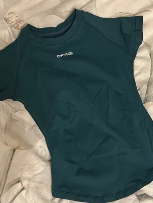 Grön topp DFYNE - Säljer denna snygga mörkgröna topp från DFYNE med korta ärmar. Perfekt för gymmet! 💚