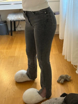 Jeans med slit - Gråa jeans från Gina Tricot med slit på sidan. Strl S, passar 34. Jätte stretchiga och bekväma. Säljer då dem är lite korta. Passar någon runt 170.