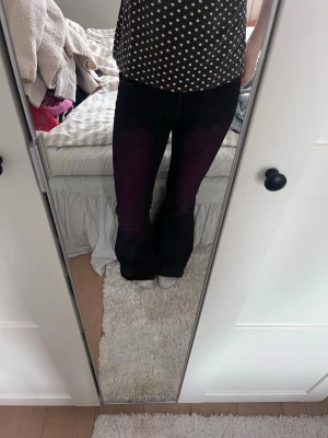 Lila/rosa bootcut jeans - Säljer ett par lila/rosa bootcut jeans med klassisk femficksdesign. Jeansen har en snygg passform som sitter tajt över låren och släpper ut vid bensluten. Tillverkade i ett stretchigt jeansmaterial för extra komfort.