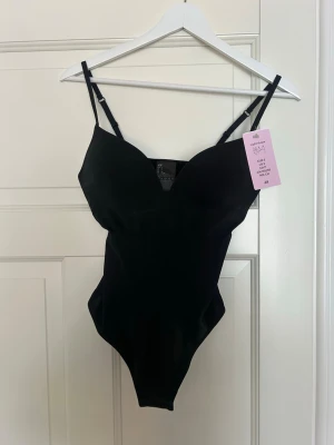 Svart body med smala axelband H&M - Säljer min svarta populära body från Hm❤️ helt ny med prislapp på
