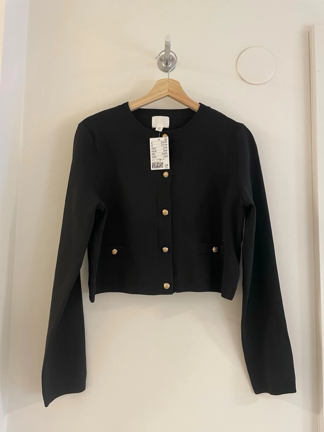 Svart kofta med guldfärgade knappar