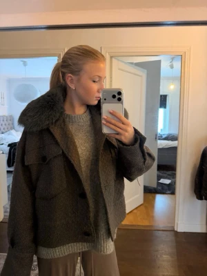Meotine mörkgrå pälsjacka med päls  - Snygg mörkgrå pälsjacka med oversized passform och stor fluffig krage i päls. Jackan har långa ärmar och en klassisk, boxig siluett. Perfekt för dig som vill ha en trendig och varm jacka med statementkrage. Är storlek L/LX men sitter som en S/M🥰