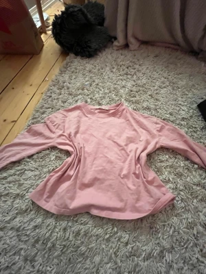 Ljusrosa långärmad tröja XS - En enkel och mjuk ljusrosa långärmad tröja från 157 i storlek XS. Tröjan har rund halsringning och är tillverkad i bomullsmaterial, perfekt för en avslappnad och chill stil.