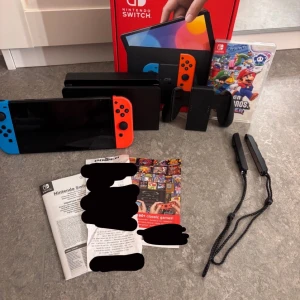 Nintendo Switch OLED + Mario spel - Nintendo Switch OLED (bättre färger och skärm) i mycket fint skick (använd 3 gånger), komplett med originalkartong, dockningsstation, Joy-Con-kontroller, handledsremmar och Super Mario Bros. Wonder-spel. Du får med kvitto och har garanti i 3 år. Du får med kod för 30 dagar gratis test på ALLA spel på nintendo. Samt att de finns många gratis spel att köra. Du får med alla sladdar som behövs. Instruktioner följer också med. Jag säljer eftersom jag inte tycker om att spela. 