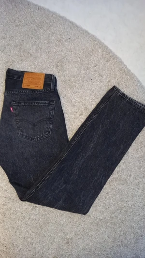 Levi's 501 jeans - Klassiska svarta Levi's 501 jeans med rak och lite lose passform med femficksdesign. Jeansen har en snygg mörk tvätt, ikonisk läderpatch bak och röd Levi's-tagg på bakfickan. Tillverkade i slitstarkt bomullsjeansmaterial. Byxorna är helt nya, säljer då jag köpte dem men aldrig riktigt känt att dem passar min stil. pris går att diskutera vid snabbt köp 🤗 ny pris 1400 köpta i butik