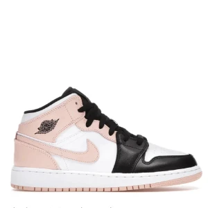 Nike Air Jordan 1 Mid rosa/svart - Nike Air Jordan 1 Mid sneakers med snygg färgblockning i ljusrosa, svart och vitt. Skorna har klassisk snörning, rund tå och platt sula. Ikoniska Jordan-loggan på sidan och Jumpman på tungan. Tillverkade i skinn med perforerade detaljer på tån för extra stil. Fint skick inga defekter alls. Lådan är inte kvar😊 Använd gärna köp nu😊💕