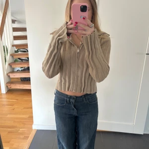 Beige ribbad tröja - Säljer en snygg beige ribbad tröja med långa ärmar. Perfekt för en stilren och bekväm look. Passar bra till jeans eller kjol. Hör av dig vid intresse!