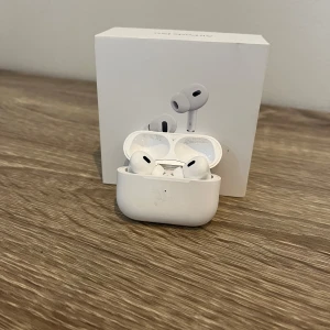 AirPods Pro gen 2 - Apple AirPods Pro med originalförpackning. Trådlösa hörlurar med aktiv brusreducering och laddningsetui. Viss smuts och slitage synligt på etuiet och insidan, men hörlurarna är nya 2 månader gamla pga utbyte hos Apple men caset är från orginalpaket köpta på Elgiganten för ca 1 år sedan