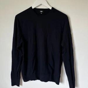 Mörkblå ulltröja från Uniqlo, M - Klassisk mörkblå tröja från Uniqlo i storlek M, tillverkad i 100% ull. Tröjan har rund hals och långa ärmar, perfekt för dig som gillar enkel och stilren design. Passar dig som vill ha en basic och tidlös look. 4A8