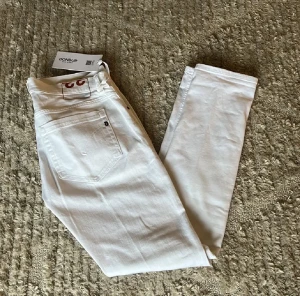 Dondup George nya - Helt nya hel vita dondups George i nyaste modellen i helt nytt skick oanvända med prislapp, inga skador eller defekter skick=10/10. Storleken på dessa jeans är w33, midja 44cm. Lår 26cm. Ytterlängd 103cm. Innerlängd 80cm. För fler frågor eller funderingar är det bara att skriva!