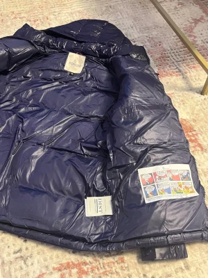 Mörkblå Moncler dunjacka med huva -  Tjo Säljer en Moncler jacka, mörkblå bra att ha nu under vinter värmer kroppen en bra färg den är ny storlek S riktigt snygg jacka och unik riktigt bra färg bra kvalitet så passa på nu att köpa jackan inför vinter. Riktig fet jacka från moncler 