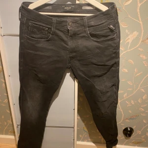 Replay Hyperflex Anbass svarta jeans - Svarta Replay Hyperflex Anbass jeans med klassisk femficksdesign och smal passform. Stretchigt material för extra komfort och rörelsefrihet. Snygga detaljer vid fickorna och diskret Replay-logga. Perfekta för dig som gillar stilrena och moderna jeans. Storlek .32/32 pruta om ni vill!