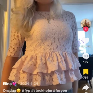 Ljusrosa spetsblus med volanger - Supersöt ljusrosa blus i spets med volangkant nertill och trekvartsärm. Tyvärr förliten för mig🥰