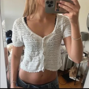 Vit stickad blus/kofta - Superfin vit stickad blus med korta ärmar och croppad passform. Blusen har v-ringning och pärlknappar framtill. Köpte den på Vinted förra veckan och har aldrig använt den