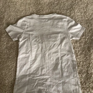 Vit t-shirt från Newbody i bomull - Säljer denna T-shirt då den inte används för att den sitter alldeles för tajt för mig. Jätte skön och jätte bra skick . Pris kan disskuteras