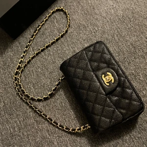 Svart lyxig väska med gulddetaljer  - Superfin väska med långt guldigt band som enkelt kan vikas in till axelväska. Tillhörande box och dustbag finns🤍