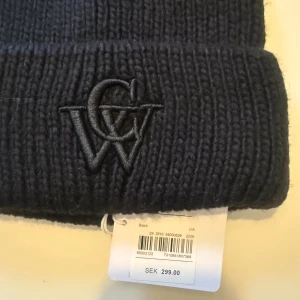 Helt ny Carin Wester mössa svart  - Helt ny Carin Wester mössa med prislapp! Nypris 300:- Svart ribbstickad mössa från Carin Wester i mjuk mohairmix. Framtill finns en snygg broderad CW-logga i svart ton. Perfekt för dig som vill ha en enkel men stilren mössa med lite extra edge.