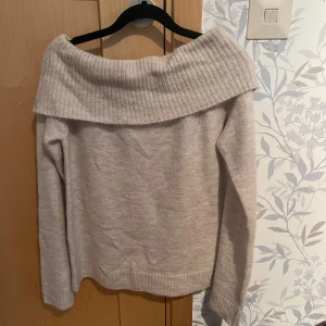 Beige offshoulder stickad tröja - Supermysig beige stickad tröja från Gina tricot med bred ribbad offshoulder-krage. Långärmad och i mjukt material som känns skönt mot huden. Har testat den en gång och pris lappen sitter fortfarande kvar