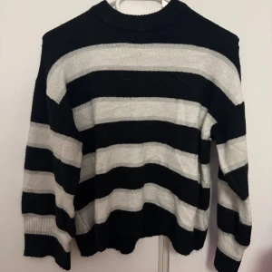 Randig svartvit stickad tröja - Säljer en stickad tröja från divided.