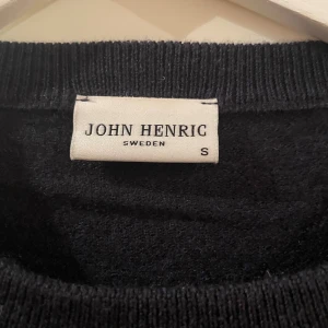 Svart merinoulltröja John Henric S - Klassisk marinblå tröja från John Henric i 100% merinoull. Rund hals och ribbade muddar vid ärmslut och nederkant. Perfekt för dig som gillar stilrena och tidlösa plagg. Långärmad och mjuk mot huden, passar dig som vill ha en enkel men snygg look. OBS den är ganska liten i storleken eftersom den krympt lite i tvätten!!!