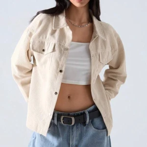 Svart manchester overshirt - Snygg svart overshirt i manchester med klassisk krage och bröstfickor med knappar. Jackan har en avslappnad passform och långa ärmar, perfekt att slänga över en crop top eller t-shirt för en chill look. Fast den är svart och inte beige.