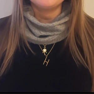 Grå tubhalsduk i mjuk ullmix - Snygg grå tubhalsduk i mjuk och stretchig ullmix. Enkel design utan mönster, perfekt att dra över huvudet för extra värme. Passar dig som gillar stilrena accessoarer och vill hålla dig varm under kyliga dagar.