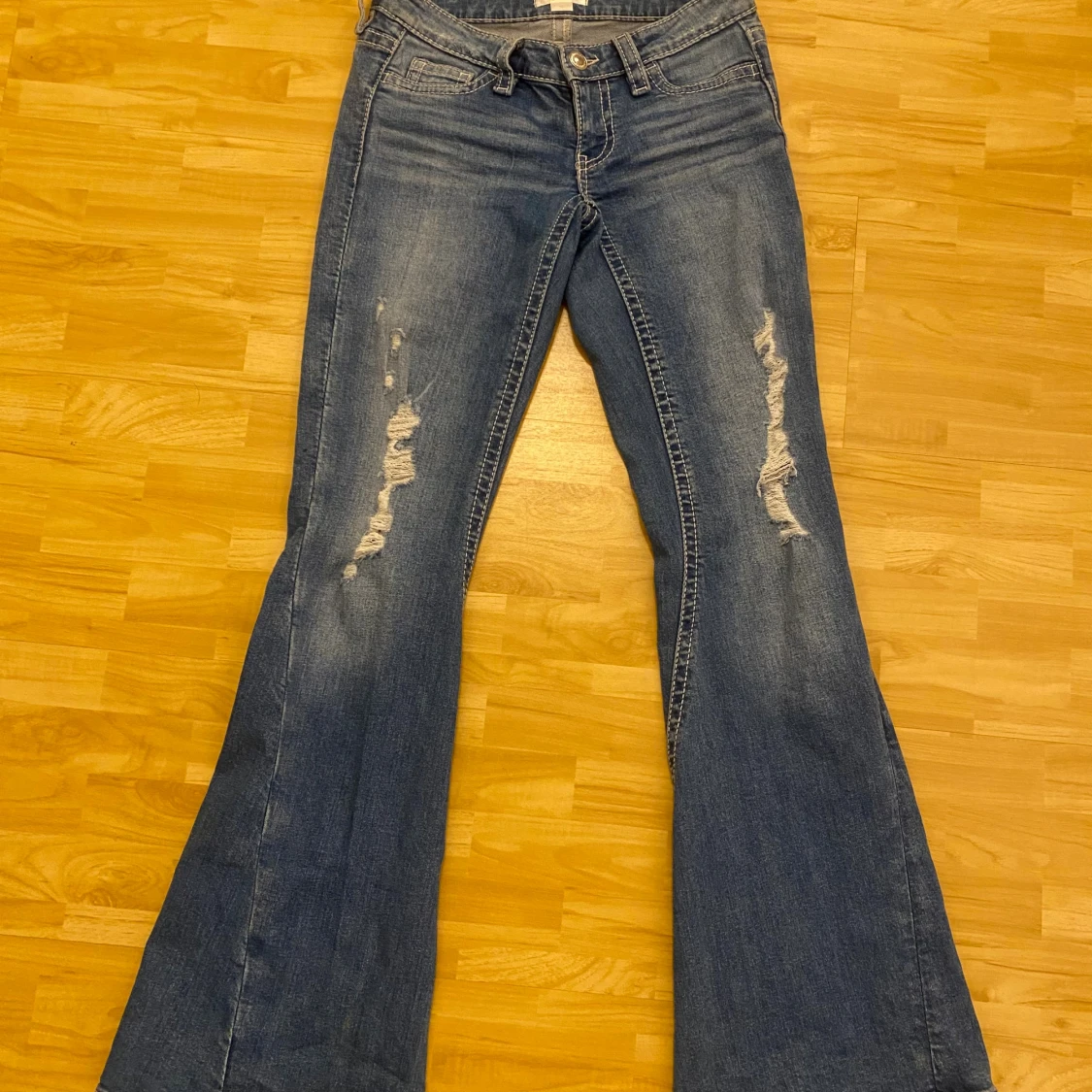 Blå bootcut jeans med slitningar