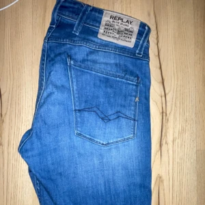 Replay blå jeans med raka ben - Snygga blå jeans från Replay med klassisk femficksdesign och raka ben. Jeansen har en cool detalj med en extra dragkedja vid fickan och tydliga sömmar på bakfickan. Perfekt passform och stilren look för dig som gillar streetwear.